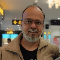 a man with a beard and glasses standing in an airport