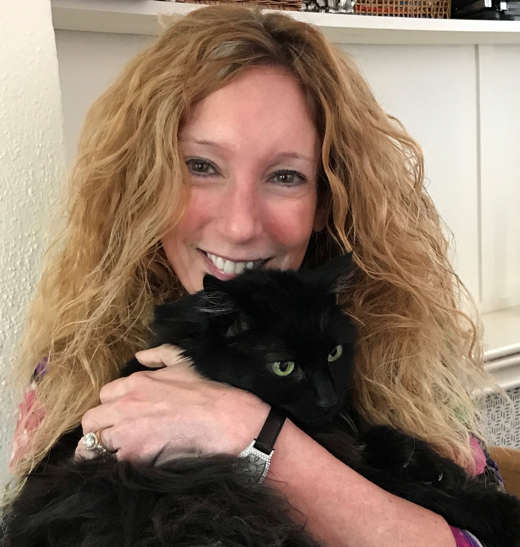 a woman holding a black cat in her arms